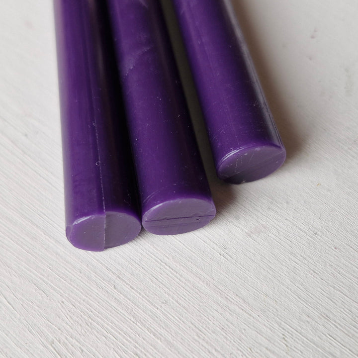 Three violet sealing wax sticks, 11mm diameter, displayed on a light surface. Suitable for crafts and sealing, part of a 10-pack.